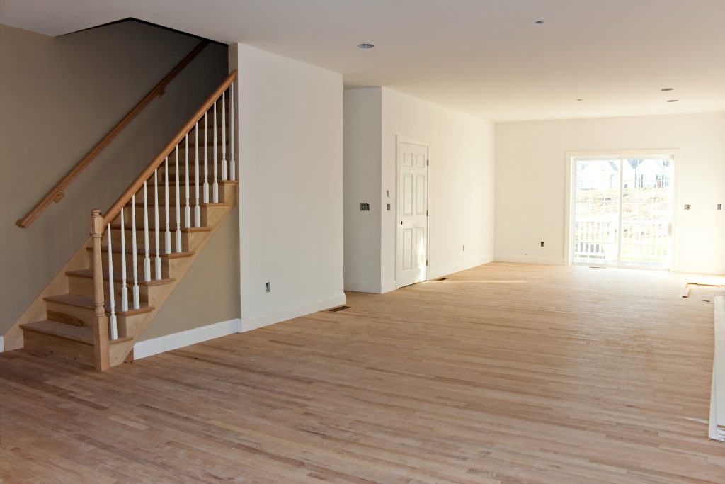 new home construction interior room with unfinished wood floors stairway and railings electrical and hvac connections also are partially unfinished StMlrWI0Hj