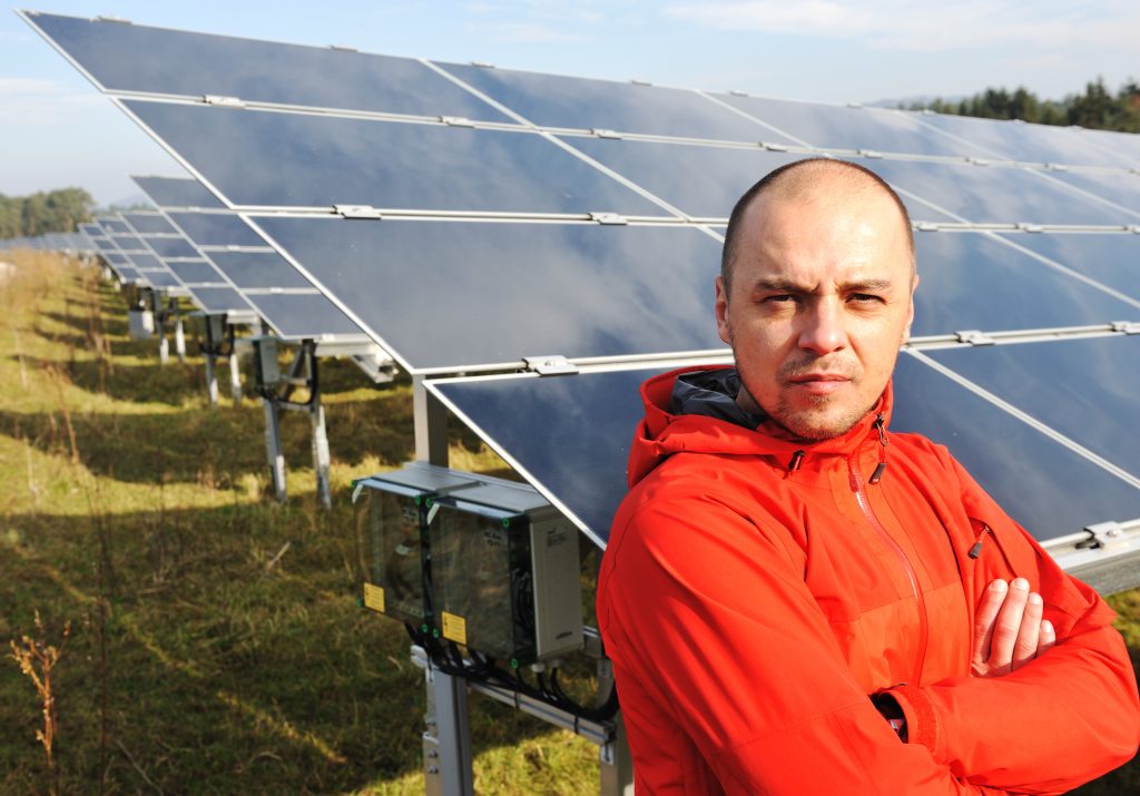 young male engineer with solar panels in background BKW01dprj