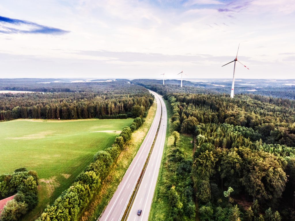 graphicstock aerial view of highway and windmills in the middle of green forest cloudy sky netherlands H G ks BGZ