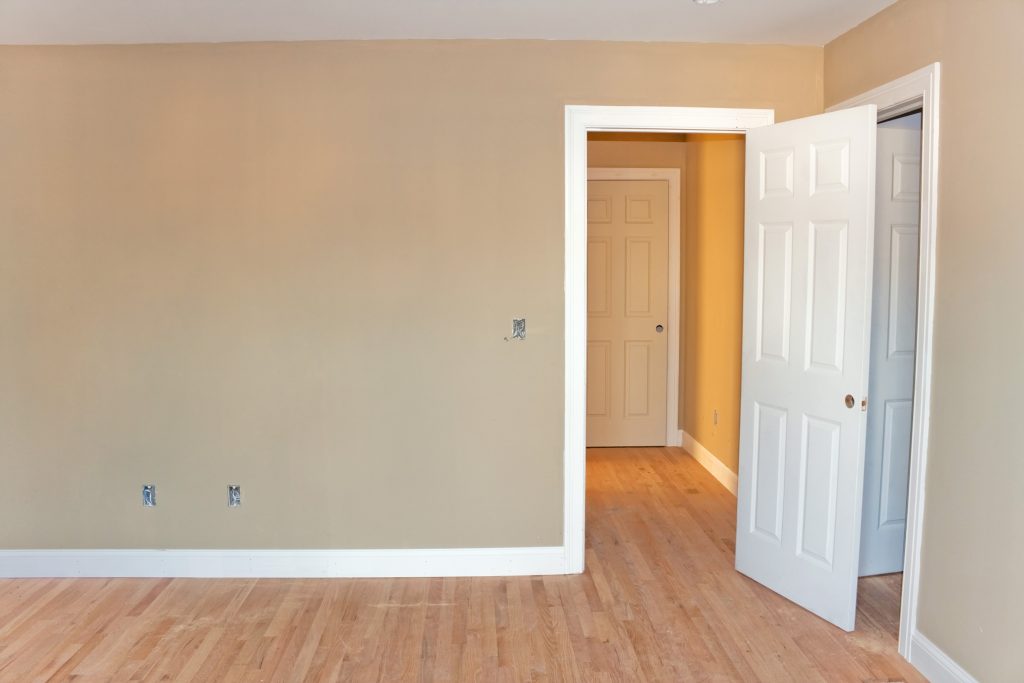 newly constructed house interior room with unfinished wood floors window and closet door electrical connections are partially unfinished BYuTX8RHs